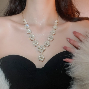 Elegant pearl flower necklace on model featuring a Y-shape design with sparkling diamond accents