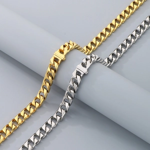 Detail view of 13mm gold and silver Cuban link necklaces on a display cylinder