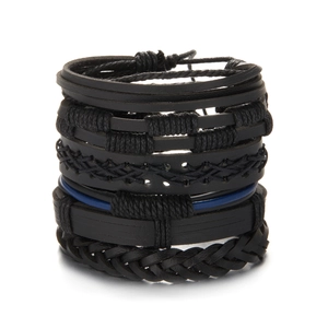 Close-up of multilayered black leather bracelets with braided ropes and adjustable cords