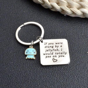 Macro shot of silver jellyfish keychain with engraved humor pendant and blue enamel charm