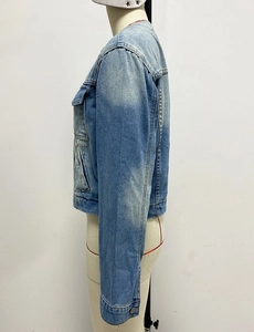 Side view detail of a cropped blue denim jacket featuring heavy wash and utility pocket