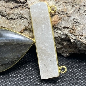 Dettaglio macro del ciondolo rettangolare in druzy bianco e labradorite a pera in oro