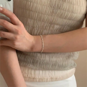 Close-up of minimalist S925 sterling silver geometric chain bracelet worn on a wrist