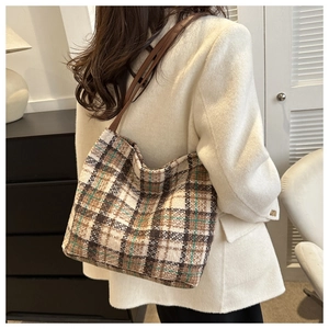 Große Retro-Tragetasche mit Karomuster aus Tweed-Stoff, von einem Model getragen