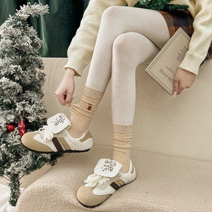Gros plan de chaussettes de Noël brodées avec des baskets d'hiver et des leggings chauds