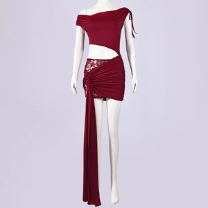 Détail d'une robe moulante asymétrique bordeaux avec dentelle et longs rubans latéraux