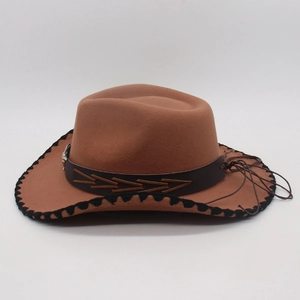 Close-up of brown western cowboy hat featuring decorative belt with metal buckle and stitching