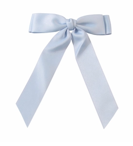 Detail of light blue satin bow hair clip with smooth ribbon texture and flowing streamers