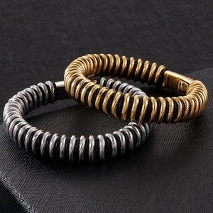 Macro view of industrial gold and silver braided steel bracelets with magnetic metal clasp