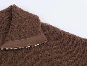 Detail of deep brown textured boucle bomber jacket with metal half-zip and collar