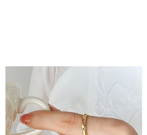 Close-up of gold-plated thin ring with inlaid red, green, and clear colorful zircons
