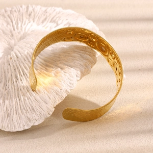Detail of 18K gold plated wide cuff bracelet with hammered texture and pearl inlay