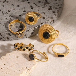 Bohemian gold stainless steel ring set with black stones on marble and volcanic stone