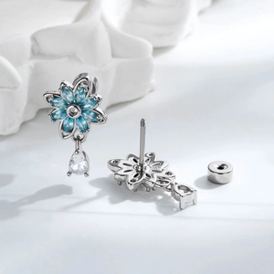Silver flower stud earrings with blue zircon petals and clear teardrop pendant