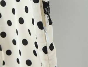 Gros plan détaillé de la fermeture éclair invisible sur une robe blanche à pois