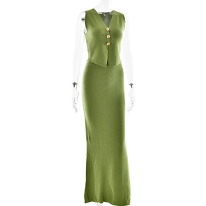 Detail of green knit set featuring V-neck vest with gold buttons and matching maxi skirt