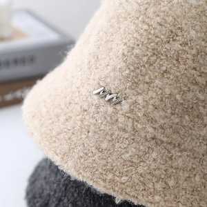 Chic beige sherpa bucket hat for women with diamond-encrusted metal accent for winter warmth