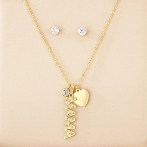 Detail of gold MAMA necklace and earrings set with heart charm on silk cloth