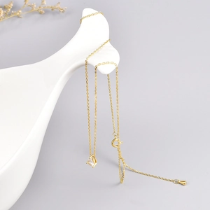 Macro view of gold stainless steel necklace with clear heart zircon pendant on white prop