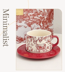 Detail of red Toile de Jouy ceramic coffee cup with forest deer print and matching saucer