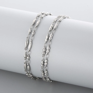 Collier minimaliste en acier inoxydable argenté avec perles sur présentoir gris