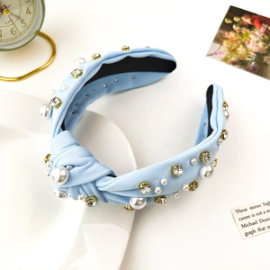Detail of light blue knotted headband featuring white pearls and sparkling rhinestones