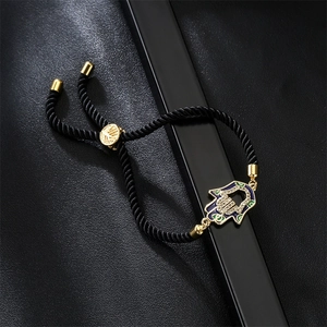 Detail of adjustable Hamsa evil eye bracelet with blue enamel and zircon on black leather