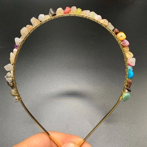 Detail of handmade gold wire headband featuring vibrant multi-color raw crystal stones