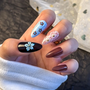 Detail view of 3D flower and plaid pattern press-on nails with almond shape design