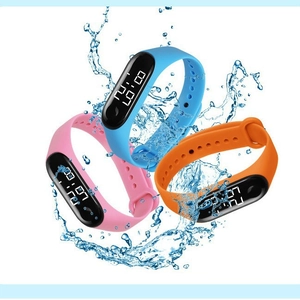 Waterproof digital LED sports watches for kids in blue, pink, and orange splashing in water