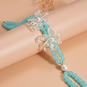 Macro detail of blue glass beads and iridescent floral charms with white pearls