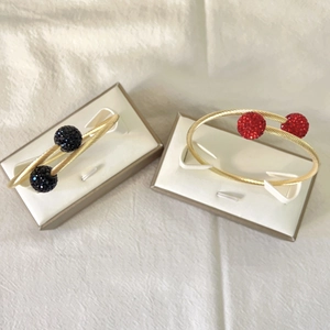 Détails de bracelets torsadés plaqués or avec boules en strass rouges et noires