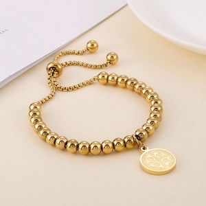 Dettaglio del bracciale a sfere regolabile in acciaio placcato oro 18K con medaglia San Benedetto