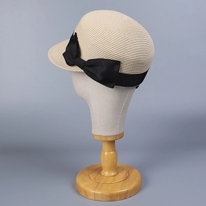 Dettaglio della trama del cappello di paglia beige con elegante nastro di gros grain nero