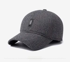 Detail view of dark grey herringbone fabric baseball cap with a leather Sport label