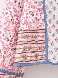 Detail of reversible quilted jacket featuring paisley prints and floral stitching