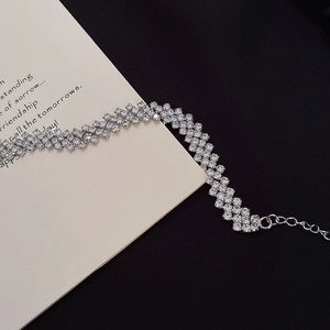 Detail of silver multi-row rhinestone choker necklace with adjustable chain on black velvet