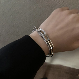 Detail of silver layered chain bracelet with rhinestone toggle on model wrist
