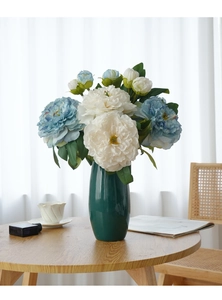 Detailed shot of white and blue artificial oil-painted peonies in a glass vase decor