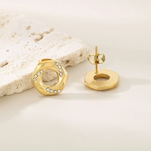 Macro shot of gold circular twisted stud earrings with sparkling cubic zirconia inlay