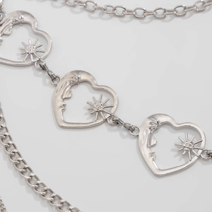 Detailed view of silver layered chain belt with gothic heart sun and moon face charms