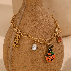 Détail du bracelet plaqué or 18K avec breloques citrouille, crâne et pierres précieuses