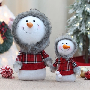 Macro detail of snowman plush figurines wearing festive red and black plaid outfits