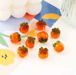 Macro shot of orange and green glass pumpkin beads for handmade DIY jewelry crafting