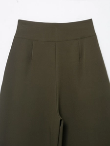 Close-up of olive green high waist pleated pants with detailed stitching and seam work