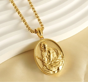 Detailed close-up of gold stainless steel religious pendant with embossed figure
