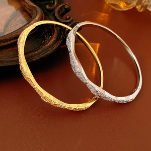 Detailed view of gold and silver quilted bracelets with pavé zircons on leather