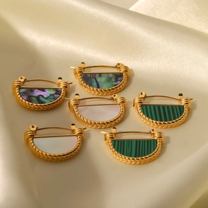 Waaiervormige schelpoorbellen in goud op een elegante zijden achtergrond in beige