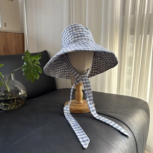 Close-up of blue gingham wide brim sun hat with adjustable long ties and embroidery