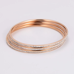 Close-up of rose gold five-piece stackable bracelets set with sparkling white crystals